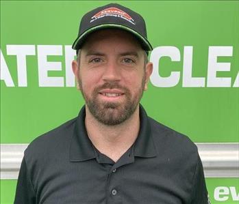 Employee head shot in front of green servpro van